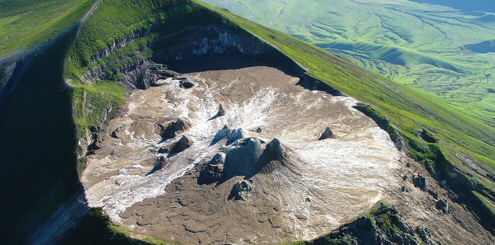 Maasai guide hiking in front of the dramatic and scenic Oldoinyo Lengai volcano in Tanzania.